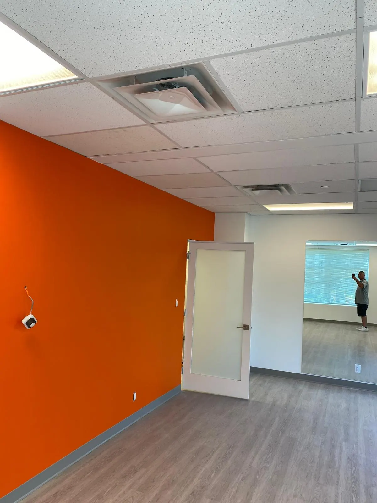 Wider view of the finished orange accent wall office suite and adjoining corridor